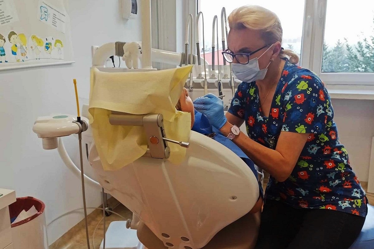 Renata Wojtal leczy zęba pacjentowi.
