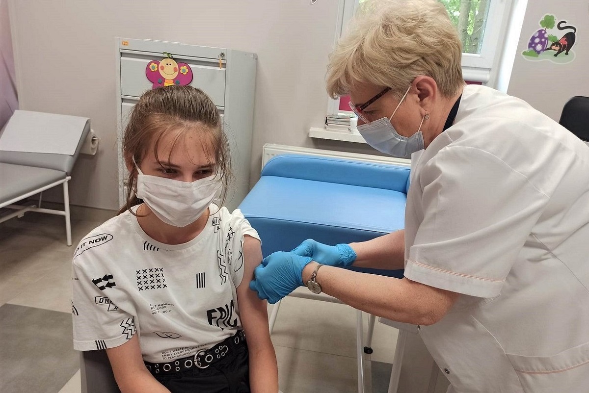 Pielęgniarka wykonuje szczepienie dziewczynce. 